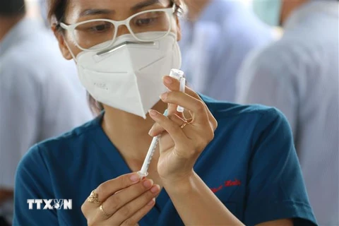 Đội y bác sỹ Trung tâm y tế Quận 7 tiêm vaccine nhắc lại phòng COVID-19 cho công nhân Công ty TNHH Juki Việt Nam (khu chế xuất Tân Thuận, Quận 7, Thành phố Hồ Chí Minh). (Ảnh: Thanh Vũ/TTXVN)