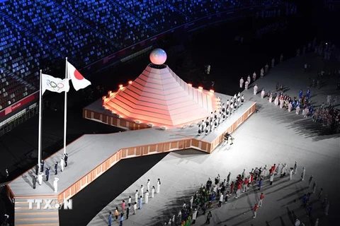 Quốc kỳ Nhật Bản (phải) và cờ Olympic tại lễ khai mạc Olympic Tokyo 2020 ở Tokyo, Nhật Bản, ngày 23/7/2021. (Ảnh: AFP/ TTXVN)