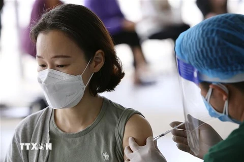 Lực lượng y tế quận Nam Từ Liêm (Hà Nội) tiêm vaccine mũi 2 cho người nước ngoài. (Ảnh: Hoàng Hiếu/TTXVN)