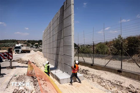 Công nhân Israel tham gia xây dựng bức tường an ninh tại phía Bắc khu Bờ Tây, ngày 22/6. (Ảnh: AFP/TTXVN)
