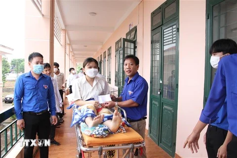 Thí sinh Hà Thanh Trâm được hỗ trợ đến điểm thi bằng cáng và xe cứu thương. (Ảnh: Đậu Tất Thành/TTXVN)