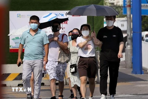 Người dân di chuyển dưới trời nắng nóng tại Thượng Hải, Trung Quốc ngày 10/7/2022. (Ảnh: THX/TTXVN)