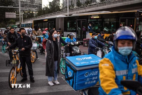 Người dân trên đường phố tại thủ đô Bắc Kinh, Trung Quốc. (Ảnh: AFP/ TTXVN)