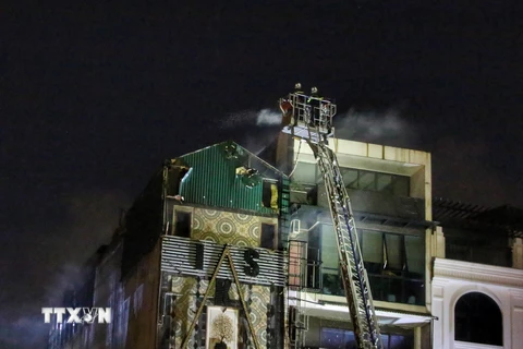 Cảnh sát Phòng cháy chữa cháy và Cứu nạn cứu hộ tiếp tục khống chế vụ cháy (ảnh chụp lúc 19h30). (Ảnh: Tuấn Đức/TTXVN)