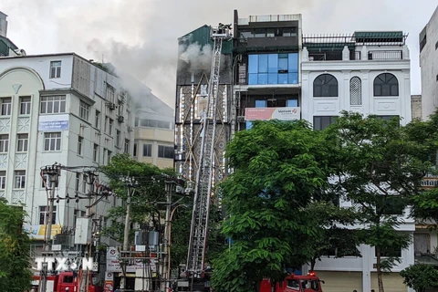 Cảnh sát phòng cháy chữa cháy và cứu nạn, cứu hộ, Công an thành phố Hà Nội đã dùng xe thang đưa lực lượng chữa cháy lên khu vực tầng thượng của ngôi nhà. (Ảnh: TTXVN phát)