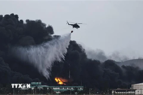 Trực thăng phun nước dập lửa tại hiện trường vụ cháy kho chứa nhiên liệu ở Matanzas, Cuba ngày 8/8/2022. (Ảnh: AFP/TTXVN)