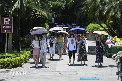 Người dân che ô tránh nắng trên đường phố tại tỉnh Phúc Kiến, Trung Quốc, ngày 24/7/2022. (Ảnh: AFP/TTXVN)