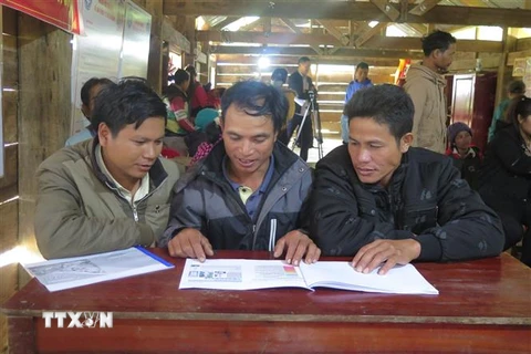 Người dân xã Măng Cành, huyện Kon Plông hiểu rõ tình hình động đất và biện pháp phòng tránh thiệt hại thông qua tài liệu tuyên truyền. (Ảnh: Dư Toán/TTXVN)