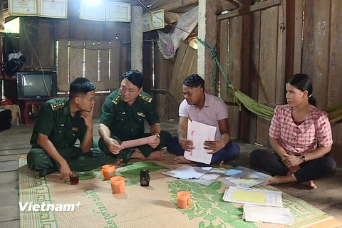 Hai vợ chồng Hồ Văn Đanh, Hồ Thị May trò chuyện với Bộ đội Biên phòng Quảng Trị. (Ảnh: Hạnh Quỳnh/Vietnam+)