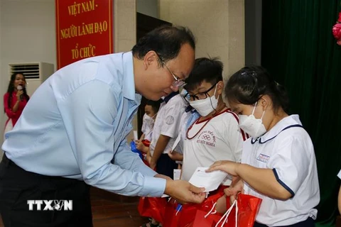 Ông Nguyễn Hồ Hải, Phó Bí thư Thành ủy Tp. Hồ Chí Minh trao học bổng cho các trẻ mồ côi do dịch COVID-19. (Ảnh: Thanh Vũ/TTXVN)