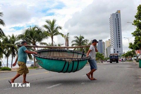 Ngư dân Đà Nẵng chủ động di chuyển thuyền thúng vào sâu đất liền để tránh bão Noru. (Ảnh: Trần Lê Lâm/TTXVN)