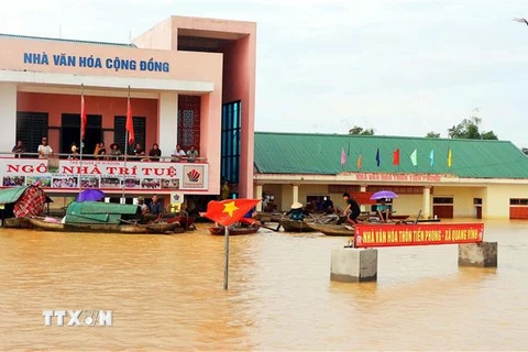 Nước lũ ngập sâu, nhân dân thôn Tiền Phong xã Quang Vĩnh huyện Đức Thọ tránh trú ở nhà văn hóa cộng đồng. (Ảnh: Công Tường/TTXVN)