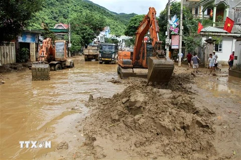 Lực lượng chức năng phải huy động nhiều máy móc để thu gom đất đá tại thị trấn Mường Xén, huyện Kỳ Sơn (Nghệ An). (Ảnh: Văn Tý/TTXVN)