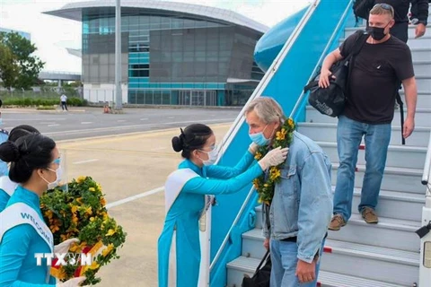 Chào đón 29 du khách quốc tế đầu tiên đến sân bay quốc tế Đà Nẵng sau đại dịch COVID-19. (Ảnh: TTXVN phát)