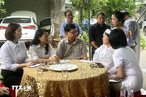 Chủ tịch Ủy ban MTTQ Việt Nam thành phố Đà Nẵng Ngô Xuân Thắng (giữa) thăm hỏi, hỗ trợ 10 triệu đồng/hộ cho các hộ gia đình có người thân tử vong trong mưa lũ. (Ảnh: Quốc Dũng/TTXVN)