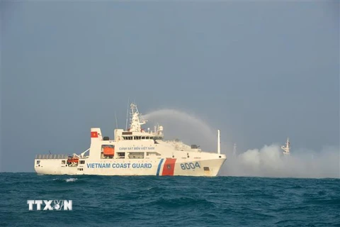 Tàu CSB 8004 thực hành phun nước dập cháy tàu bị nạn trong luyện tập phối hợp tìm kiếm cứu nạn. (Ảnh: TTXVN phát)