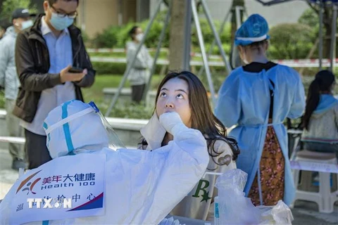 Nhân viên y tế lấy mẫu xét nghiệm COVID-19 cho người dân tại tỉnh Tứ Xuyên, Trung Quốc, ngày 17/9. (Ảnh: AFP/ TTXVN)