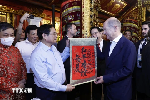 Thủ tướng Phạm Minh Chính tặng Thủ tướng Đức Olaf Scholz bức thư pháp với nội dung "Hòa bình - Hữu nghị cùng phát triển" tại đền Ngọc Sơn. (Ảnh: An Đăng/TTXVN)