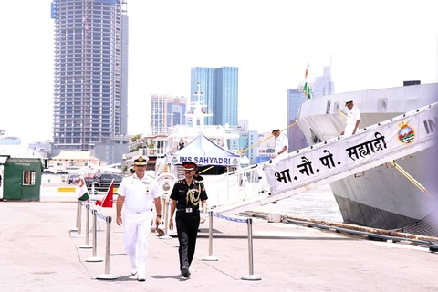 Chuẩn Đô đốc Sanjay Bhalla, Thống soái chỉ huy Hạm đội phía Đông của Hải quân Ấn Độ (áo trắng, bên trái) xuống tàu thực hiện nghi lễ cập cảng Nhà Rồng. (Ảnh: Xuân Khu/TTXVN)