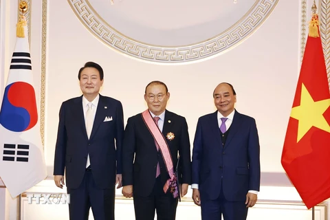 Chủ tịch nước Nguyễn Xuân Phúc chứng kiến Tổng thống Hàn Quốc Yoon Suk-yeo trao huân chương Người truyền cảm hứng cho huấn luyện viên Park Hang-seo. (Ảnh: Thống Nhất/TTXVN)