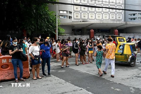 Người dân tại Manila, Philippines, sơ tán ra bên ngoài các tòa nhà sau trận động đất ngày 27/7/2022. (Ảnh minh họa: AFP/ TTXVN)
