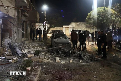 Các phương tiện và nhà cửa bị phá hủy sau vụ tấn công bằng rocket tại thị trấn Azaz, tỉnh Aleppo, Syria, ngày 22/11. (Ảnh: AFP/ TTXVN)