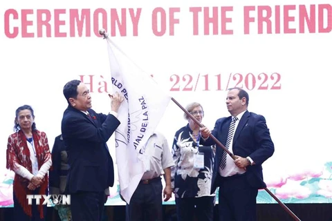 Phó Chủ tịch thường trực Quốc hội Trần Thanh Mẫn ký lên lá cờ của Hội đồng Hòa bình thế giới. (Ảnh: Minh Đức/TTXVN)