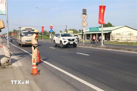 Tổ cảnh sát giao thông làm nhiệm vụ trên Quốc lộ 1 thuộc huyện Châu Thành, Tiền Giang. (Ảnh: Minh Trí/TTXVN)