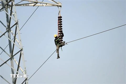 Kỹ thuật viên sửa chữa đường dây điện cao thế tại Karachi, Pakistan. (Ảnh: AFP/ TTXVN)