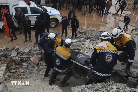 Lực lượng cứu hộ chuyển nạn nhân ra khỏi đống đổ nát sau trận động đất tại tỉnh Idlib, Syria ngày 6/2/2023. (Ảnh: AFP/TTXVN)