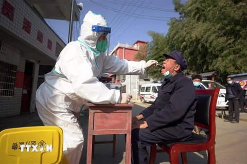 Nhân viên y tế lấy mẫu xét nghiệm COVID-19 cho người dân tại tỉnh Quý Châu, Trung Quốc ngày 21/12/2022. (Ảnh: AFP/TTXVN)