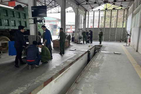Cơ quan Cảnh sát điều tra Công an tỉnh Lào Cai thực hiện lệnh khám xét, niêm phong các hồ sơ, tài liệu liên quan tại Trung tâm đăng kiểm xe cơ giới 2401D. (Nguồn: Báo Lao Động)