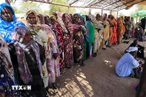 Phụ nữ Sudan chờ nhận hàng cứu trợ tại trại tị nạn dành cho những người mất nhà cửa do chiến tranh ở Nyala, Nam Darfur. (Ảnh: AFP/TTXVN)