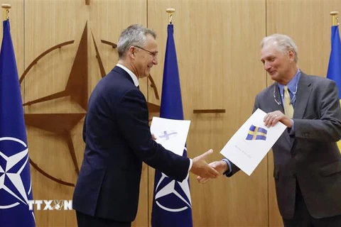 Tổng Thư ký NATO Jens Stoltenberg (trái) tiếp nhận đơn xin gia nhập liên minh quân sự từ đại sứ Thụy Điển tại NATO Axel Wernhoff ở Brussels (Bỉ), ngày 18/5/2022. (Ảnh: AFP/TTXVN)