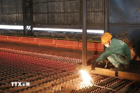 Công nhân Nhà máy cán thép Thái Trung - Công ty cổ phẩn Gang thép Thái Nguyên lấy mẫu thép thành phẩm sau khi cán. (Ảnh: Hoàng Nguyên/TTXVN)