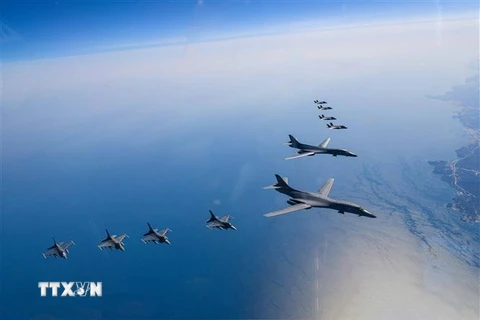 Máy bay ném bom chiến lược B-1B (phải) của Mỹ cùng chiến đấu cơ tàng hình F-35A (phải, trên) của Hàn Quốc và máy bay chiến đấu F-16 (dưới) của Mỹ tham gia cuộc tập trận chung trên bầu trời Bán đảo Triều Tiên ngày 19/3/2023. (Ảnh: AFP/TTXVN)