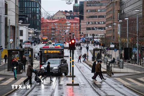 Người dân di chuyển trên đường phố tại Stockholm, Thụy Điển. (Ảnh: AFP/TTXVN)