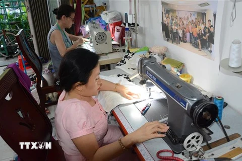 Nhóm phụ nữ khuyết tật đang làm ra những sản phẩm thời trang từ các loại vải thải thu gom được. (Ảnh minh họa: Văn Dũng/TTXVN)