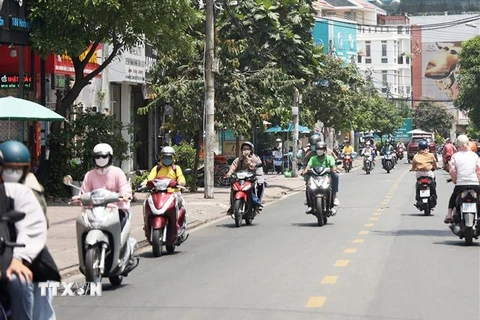 Người dân lưu thông bằng xe gắn máy trưa ngày 27/4 trên đường Hoàng Diệu, thành phố Thủ Đức. (Ảnh: Hồng Đạt/TTXVN)