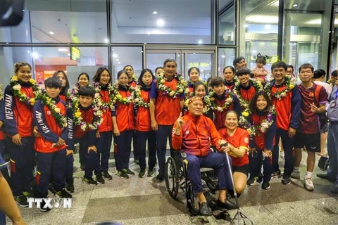 Đội tuyển bóng đá nữ Việt Nam cùng người hâm mộ tại sân bay quốc tế Nội Bài. (Ảnh: Tuấn Đức/TTXVN)