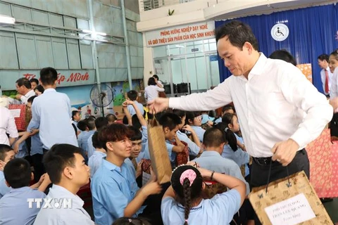 Phó Thủ tướng Trần Lưu Quang tặng quà cho các em học sinh ở Trung tâm Phục hồi chức năng - Giáo dục trẻ em khuyết tật tỉnh Khánh Hòa. (Ảnh: Phan Sáu/TTXVN)