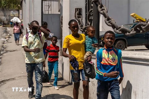 Người dân rời bỏ nhà cửa sau cuộc tấn công của bang nhóm tội phạm tại Port-au-Prince, Haiti. (Ảnh: AFP/TTXVN)