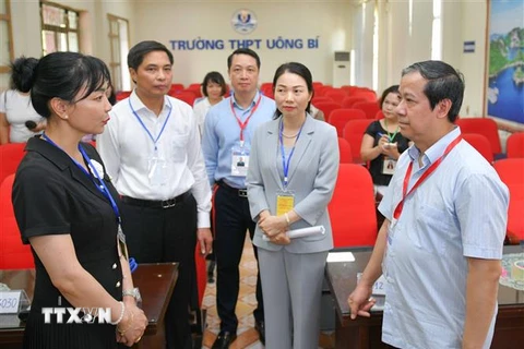 Bộ trưởng Bộ Giáo dục và Đào tạo Nguyễn Kim Sơn nghe báo cáo về công tác coi thi tại điểm thi Trường THPT Uông Bí, tỉnh Quảng Ninh. (Ảnh: Thanh Tùng/TTXVN)