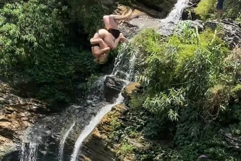 Hình ảnh du khách nước ngoài ôm nhau nhảy xuống thác Du Già hồi tháng 5. (Nguồn: Thanh Niên)