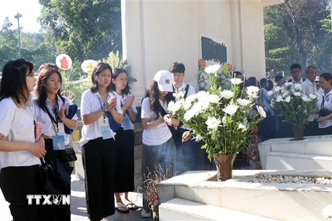 Thanh niên, sinh viên Kiều bào dâng hương tại mộ 10 Nữ Anh hùng Liệt sỹ Thanh niên Xung phong. (Ảnh: Công Tường/TTXVN)
