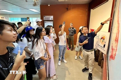 Đoàn thanh niên, sinh viên Kều bào thăm quan Trung tâm Trưng bày Hoạt động Khắc phục Hậu quả Bom mìn tại Quảng Trị. (Ảnh: Nguyên Linh/TTXVN)
