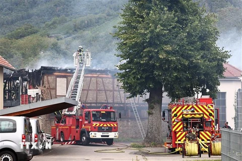 Lực lượng cứu hỏa nỗ lực dập lửa tại hiện trường vụ cháy nhà nghỉ dưỡng ở Wintzenheim, miền Đông Pháp, ngày 9/8. (Ảnh: AFP/TTXVN)