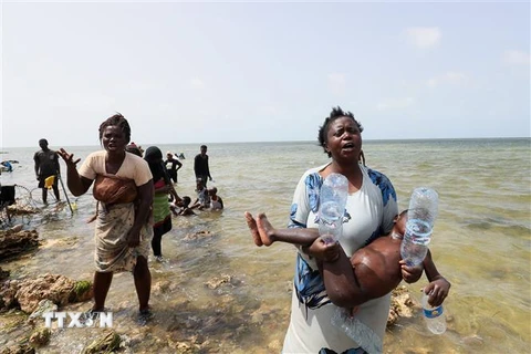 Người di cư từ châu Phi bị mắc kẹt trên bờ biển tại khu vực biên giới Libya và Tunisia, ngày 26/7. (Ảnh: AFP/TTXVN)