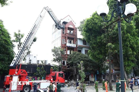 Lực lượng Phòng cháy Chữa cháy và Cứu nạn Cứu hộ sử dụng xe thang chuyên dụng để tiếp cận hiện trường vụ nổ. (Ảnh: Phạm Kiên/TTXVN)