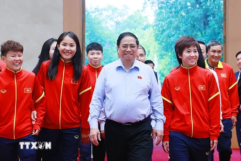 Thủ tướng Phạm Minh Chính tặng hoa cho các cầu thủ Đội tuyển Bóng đá Nữ Quốc gia Việt Nam. (Ảnh: Dương Giang/TTXVN)
